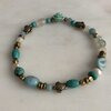 Armband met kraaltjes van diverse soorten half-edelsteen en bronzen details