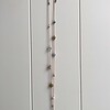 Lange geknoopte ketting met diverse soorten half-edelstenen en hanger in de vorm van een kever