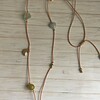 Lange geknoopte ketting met diverse soorten half-edelstenen en hanger in de vorm van een kever