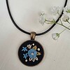 Unieke geborduurde hanger met blauwe roos