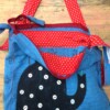 Blauwe tas met theepot en geborduurde bloemen