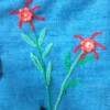 Blauwe tas met theepot en geborduurde bloemen