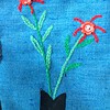 Blauwe tas met theepot en geborduurde bloemen