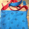 Blauwe tas met theepot en geborduurde bloemen