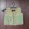 Groene wollen gilet met bloemenbandje