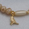 Handgemaakte armband met vergulde bedel - beige