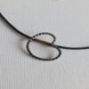 Zilveren Pompeblêd hanger, aan zwart rubber koord