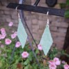 Lichtgroene oorbellen van satin-silk glaskralen – met zilveren haakje, 7 cm