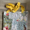 Tote bag van een doorgestikte sprei met bloemen, vlinders en vogels