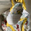 Tote bag van een doorgestikte sprei met bloemen, vlinders en vogels
