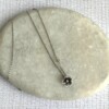 Verzilverde ketting met bloemetje en peridoot kraaltje