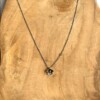 Verzilverde ketting met bloemetje en peridoot kraaltje