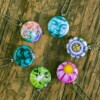 Roestvrij stalen fotomedaillon ketting in teal blauw met drie verschillende verwisselbare voorkanten met close up foto`s in pauw blauw.Pauwenveer close up. Rvs/roesvrij stalen fotomedaillon. Voor het dicht bij je dragen van je favoriete foto.