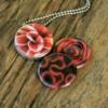 Roestvrij stalen fotomedaillon ketting met drie verschillende verwisselbare voorkanten met close up foto`s in Diep donker rood,zalm en warm rood. Rvs/roesvrij stalen fotomedaillon. Voor het dicht bij je dragen van je favoriete foto.