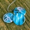 Roestvrij stalen fotomedaillon ketting met drie verschillende verwisselbare voorkanten met close up foto`s van ijsblauw glas,aqua blauw glas. Rvs/roesvrij stalen fotomedaillon. Voor het dicht bij je dragen van je favoriete foto.