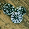 Roestvrij stalen fotomedaillon ketting met drie verschillende verwisselbare voorkanten met close up foto's van bloemen en planten in zwart wit.Rvs/roesvrij stalen fotomedaillon. Voor het dicht bij je dragen van je favoriete foto.