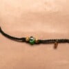 Gevlochten donkergroene armband met gekraakte kralen en goudkleurig blaadje