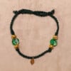 Gevlochten donkergroene armband met gekraakte kralen en goudkleurig blaadje