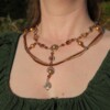 Ketting met blad-hanger, bruin lint en goudkleurige kralen