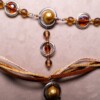 Ketting met blad-hanger, bruin lint en goudkleurige kralen