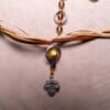 Ketting met blad-hanger, bruin lint en goudkleurige kralen