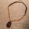 Ketting met bloemenornament in antiek koper en amberkleurige kralen