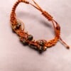 Koperkleurige macramé-armband met goudkleurige kralen