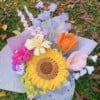 Handgemaakt haakboeket met grote zonnebloem en kleurrijke veldbloemen