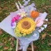 Handgemaakt haakboeket met grote zonnebloem en kleurrijke veldbloemen