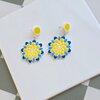 Handgemaakte geel, blauw en witte oorbellen van polymeerklei en kralen | Bloem