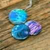 Roestvrij stalen foto medaillon ketting met close up afbeeldingen van blauw paars en groen glas.Magische tinten paars blauw voor je medaillon ketting.. Rvs/roesvrij stalen fotomedaillon. Voor het dicht bij je dragen van je favoriete foto.
