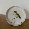 Vogel op een rond bordje met standaard.