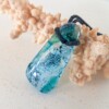 Handgemaakte hanger van versmolten glas in aqua turquoise blauw, groen en zwart, inclusief verstelbare ketting.