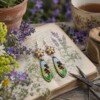 Bloementuin & Zomerbries, cottagecore oorbellen met emaille bedels en geweven bloemetjes