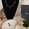 Set van oorbellen en halsketting met rode glazen druppels