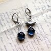 Asymmetrische handgemaakte vogeloorbellen met blauw glas en zilverkleurig koper