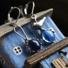 Asymmetrische handgemaakte vogeloorbellen met blauw glas en zilverkleurig koper