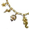 Goudkleurige halsketting met goudkleurige metalen bedels. Handgemaakte ketting met goudkleurige schakels, sluiting en bedel strand zee zomer