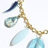 Goudkleurige schakelketting met hangers van schelp, parelmoer, kunsthars en glas. Modieuze halsketting met turquoise bedel, Per Elle ketting