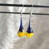 Handgeblazen druppeloorbellen van blauw en geel glas en zilverkleurig koper