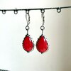 Handgemaakte druppeloorbellen met rood glas en zilverkleurig koper