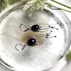 Handgemaakte kwallenoorbellen met zwart glas en zilverkleurig koper