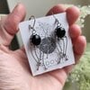 Handgemaakte kwallenoorbellen met zwart glas en zilverkleurig koper