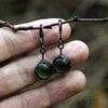 Handgemaakte oorbellen met groen glas en zwart gepatineerd koper