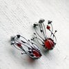 Handgemaakte paddenstoelenbroche met rood glas en zilverkleurig koper