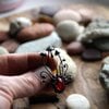 Handgemaakte paddenstoelenbroche met rood glas en zwart gepatineerd koper