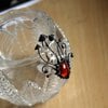 Handgemaakte paddenstoelenbroche met rood glas en zwart gepatineerd koper