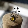 Handgemaakte paddenstoelenclusterbroche met geel glas en zwart gepatineerd koper
