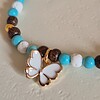 Vrolijke witte/gouden vlinder armband