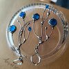 Asymmetrische handgemaakte takoorringen met blauw glas en zilverkleurig koper